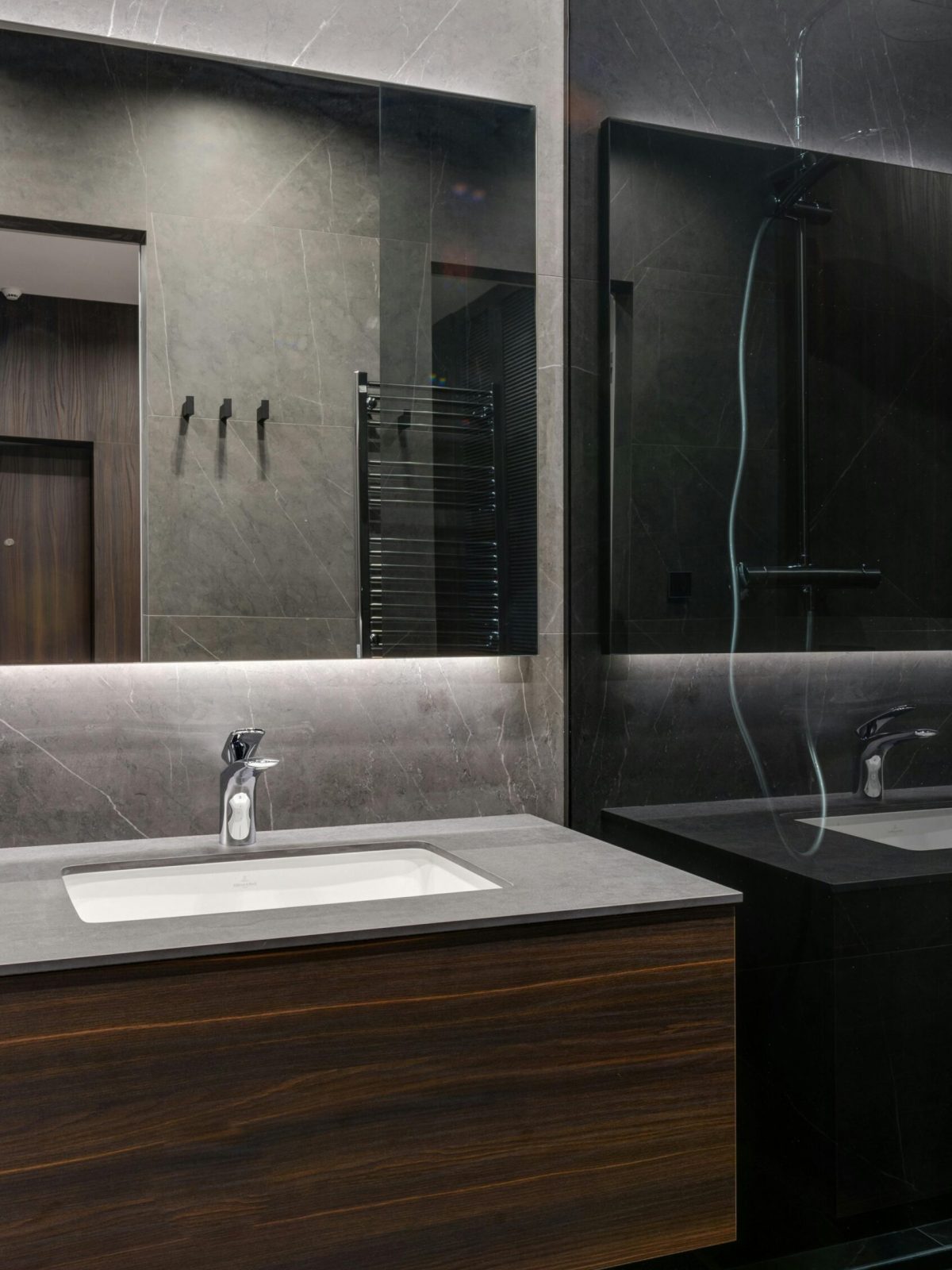 Elegant contemporary bathroom with marble surfaces and wooden vanity.